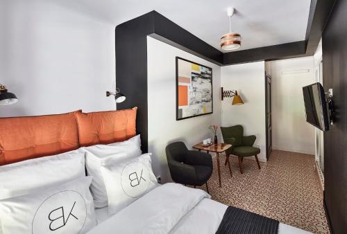 a bedroom with a bed with an orange headboard at Bez Kantów Art Rooms in Warsaw