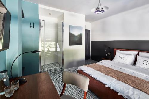 a bedroom with a bed and a desk and a table sidx sidx sidx at Bez Kantów Art Rooms in Warsaw