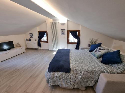 1 dormitorio con 1 cama grande con almohadas azules en Mansarda al mare, en Rapallo