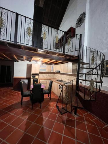 una sala de estar con una escalera de caracol y sillas en Casa Faccioli, en Mompox