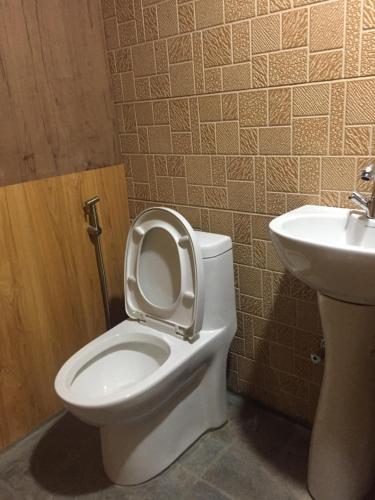 a bathroom with a toilet and a sink at Tribeni Lodge Restaurant And Bar in Phakding