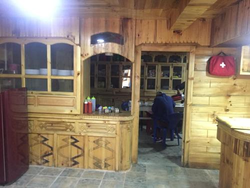 a kitchen with wooden cabinets and a table in it at Tribeni Lodge Restaurant And Bar in Phakding