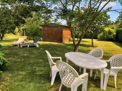 einen weißen Tisch und Stühle im Hof in der Unterkunft La petite corbière - Chez Hélène - Gîtes en baie in Jullouville-les-Pins