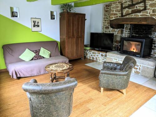 ein Wohnzimmer mit Couch und Kamin in der Unterkunft La petite corbière - Chez Hélène - Gîtes en baie in Jullouville-les-Pins