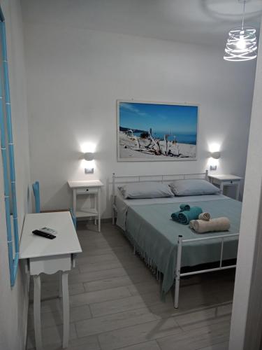 une chambre avec un lit, un bureau et une table dans l'établissement B&B S'Incantu, à SantʼAnna Arresi