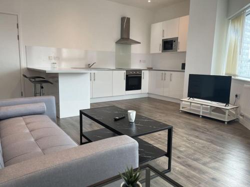 a living room with a couch and a table at Bright & Spacious Flat In London in Croydon