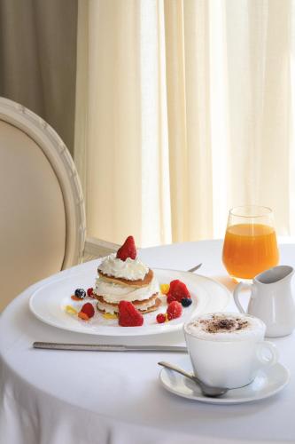 a plate with a cake and berries on a table at Boscolo Nice Hotel & Spa in Nice