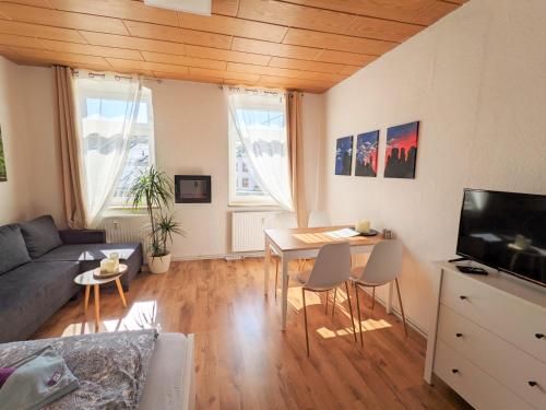 - un salon avec un canapé et une table dans l'établissement Urlaubsmagie - Helle Wohnung mit Garten & Pool - R3, à Rathmannsdorf