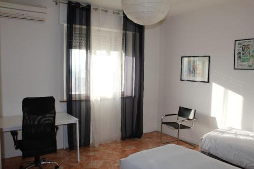 sypialnia z łóżkiem, biurkiem i krzesłem w obiekcie VIALETORINO26 Luminoso e grande appartamento w mieście Vicenza