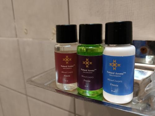 three bottles of liquids sitting on a shelf at Hotel Nirvana Lakeside in Udaipur