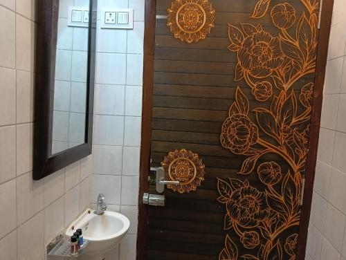 baño con aseo, lavabo y puerta en Hostel Nirvana, en Udaipur