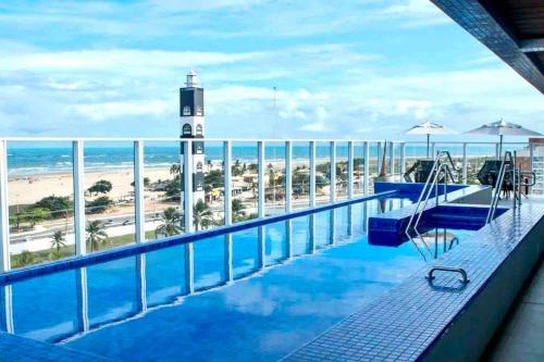 uma piscina com vista para a praia e um farol em Novíssimo ,ótima localização. em Aracaju