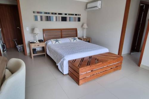 ein Schlafzimmer mit einem Bett und zwei Nachttischen und zwei Lampen in der Unterkunft Recanto dos Canários - Búzios in Búzios