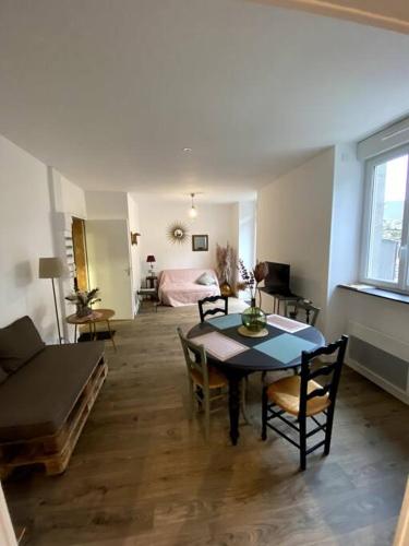 sala de estar con mesa, sillas y cama en Appartement COSY en Sartilly