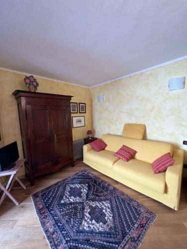 a bedroom with a large yellow bed and a rug at Casa Agnes in Bardonecchia
