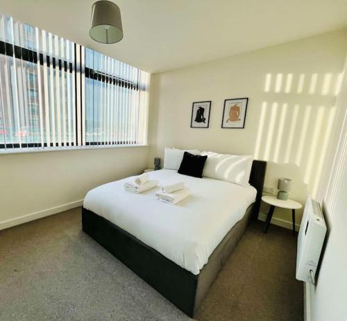 een slaapkamer met een groot bed en een raam bij Old Trafford: Self-Serviced One Bedroom Apartment in Manchester