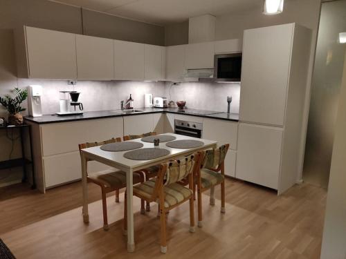 a kitchen with a table and some chairs and a refrigerator at Merikorte in Naantali