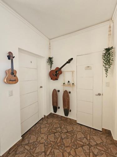 a room with two guitars on the wall at Sunset Surf Villa in La Libertad