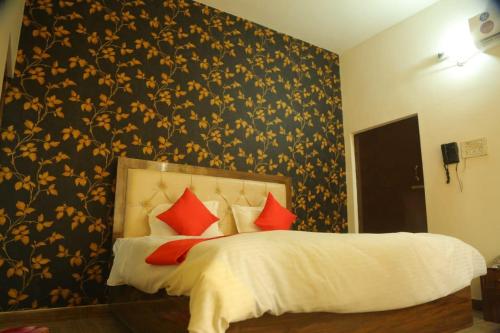 a bedroom with a large bed with red pillows at Divine sparrow family homestay in Agra