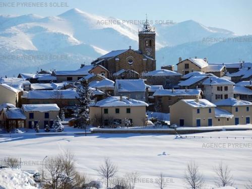 a town covered in snow with a clock tower at Appartement familial, 2 chambres, balcon S-E, à 30m pistes et Balnéo, Les Angles - FR-1-295-135 in Les Angles