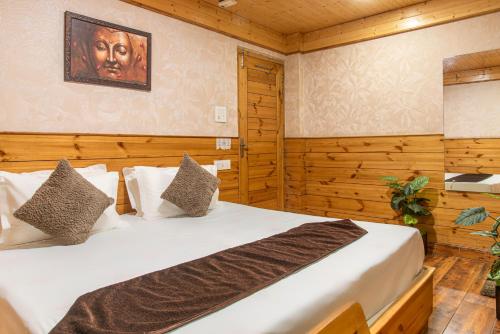 a bedroom with two beds and a painting on the wall at The Tikker in Shimla
