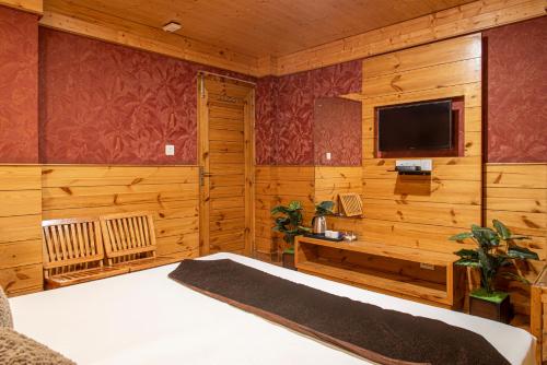 a bedroom with a bed and a flat screen tv at The Tikker in Shimla
