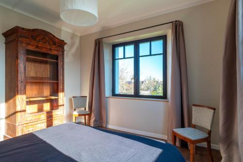 - une chambre avec un lit, une fenêtre et 2 chaises dans l'établissement Portamaneg - Grande maison familiale Port-Manech, à Névez