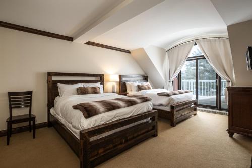 a bedroom with two beds and a large window at Tremblant Prestige - Bondurant 95-15 in Mont-Tremblant
