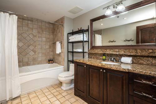 a bathroom with a tub and a toilet and a sink at BONDURANT 95-15 / Luxury 3 bdr on the village in Mont-Tremblant