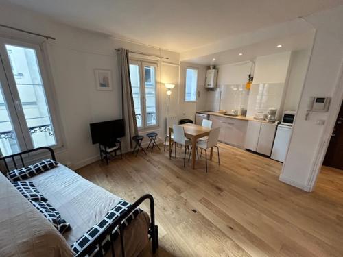une chambre avec un lit et une cuisine avec une table dans l'établissement Paris Sacré Coeur Montmartre et Tour Eiffel, 8 people,, à Paris