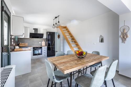 a kitchen and dining room with a wooden table and chairs at Marani Home & Villas in Skopelos Town