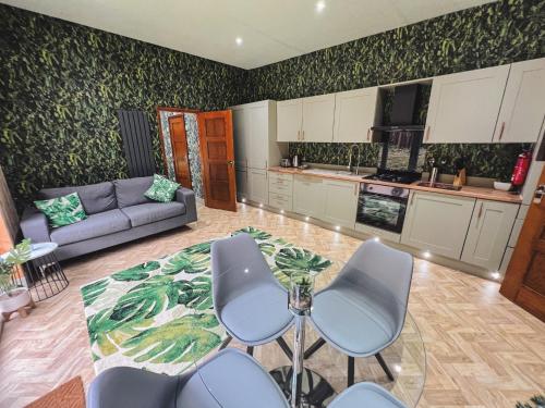 a living room with a couch and a table and chairs at Woodlakes Park By Liv Retreats in Kings Lynn
