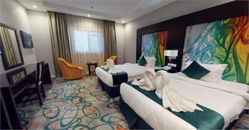 um quarto de hotel com duas camas com toalhas em فندق الراحة السويسرية em Jidá