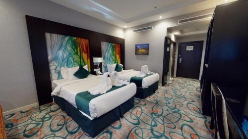 een hotelkamer met twee bedden met witte schoenen erop bij فندق الراحة السويسرية in Jeddah
