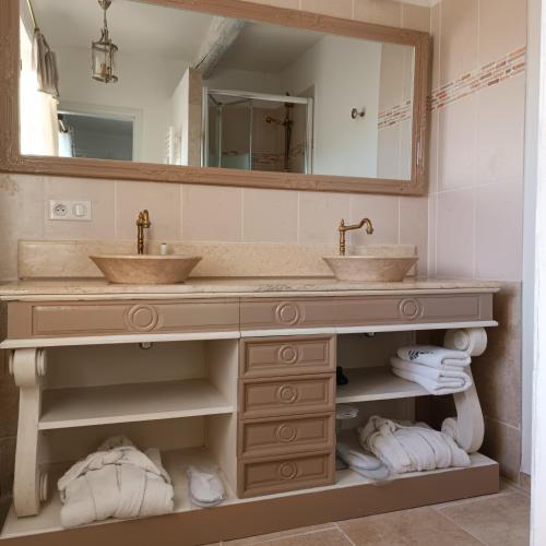une salle de bain avec deux lavabos et un grand miroir dans l'établissement Chambre d'hôtes du Mas de Longuefeuille, à Malaucène