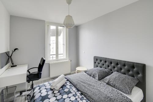 a bedroom with a bed and a desk and a chair at Chic and spacious apart with parking in Cergy