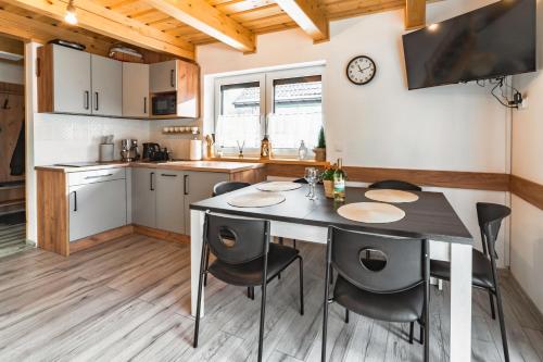 a kitchen and dining room with a table and chairs at Domki Wichrowe Wzgórze in Wisła