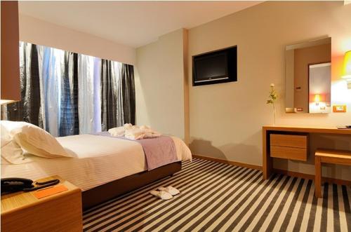 Galaxy City Center Hotel tesisinde bir odada yatak veya yataklar