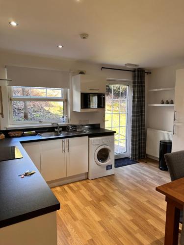 a kitchen with a washer and dryer at Apartment in Queens Court, Banchory in Inchmarlo
