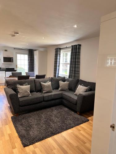 a living room with a couch and a kitchen at Apartment in Queens Court, Banchory in Inchmarlo