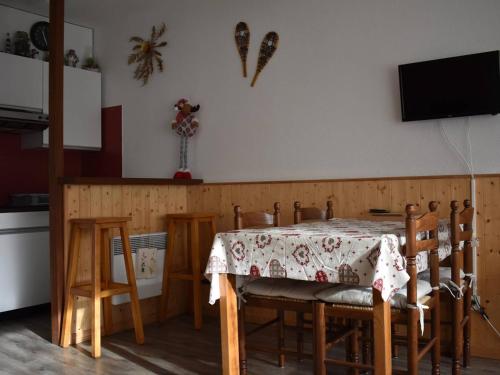 une salle à manger avec une table et des chaises et une télévision dans l'établissement Charmant studio cabine avec terrasse et parking à Font-Romeu - FR-1-580-58, à Font-Romeu-Odeillo-Via