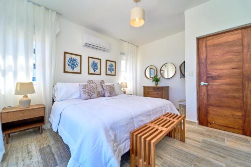 a bedroom with a large bed with a wooden door at Cana Brava Residences-Comfort Condo in Punta Cana
