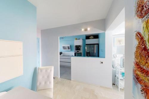 Cette chambre dispose de murs blancs et d'une chaise blanche. dans l'établissement Marina - Blue Sea View - Beach - Private Parking, à Villeneuve-Loubet