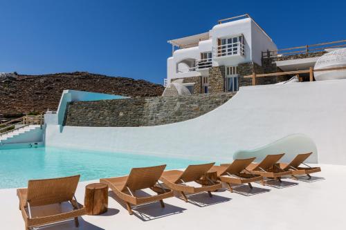a row of chairs next to a swimming pool at Villa Sera Mykonos in Glastros