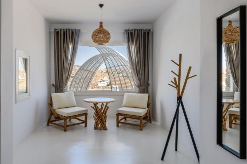 a room with a table and chairs and a window at Villa Sera Mykonos in Glastros