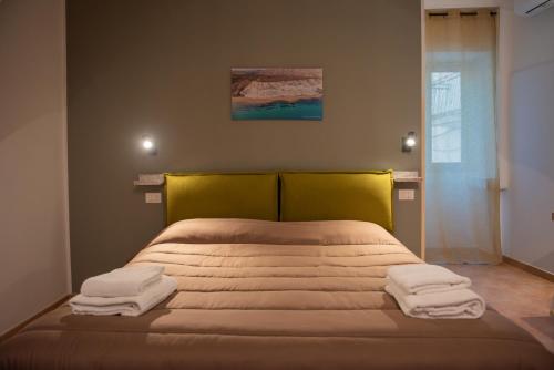 a bedroom with a bed with towels on it at La Casetta di Giorgio in Siculiana