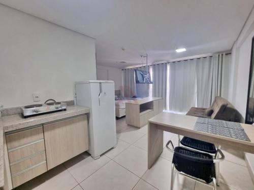 a kitchen with a white refrigerator and a table at Flat Brookfield Towers in Goiânia