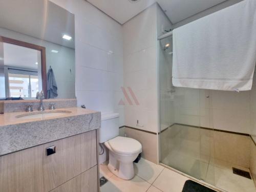 uma casa de banho com um chuveiro, um WC e um lavatório. em Flat Brookfield Towers em Goiânia