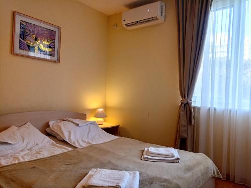1 dormitorio con 1 cama con 2 toallas en Family Apartament Marina-Bastet BS, en Sveti Vlas