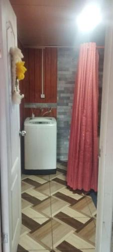 uma casa de banho com um lavatório e uma cortina de chuveiro rosa em Departamento céntrico quellón em Quellón
